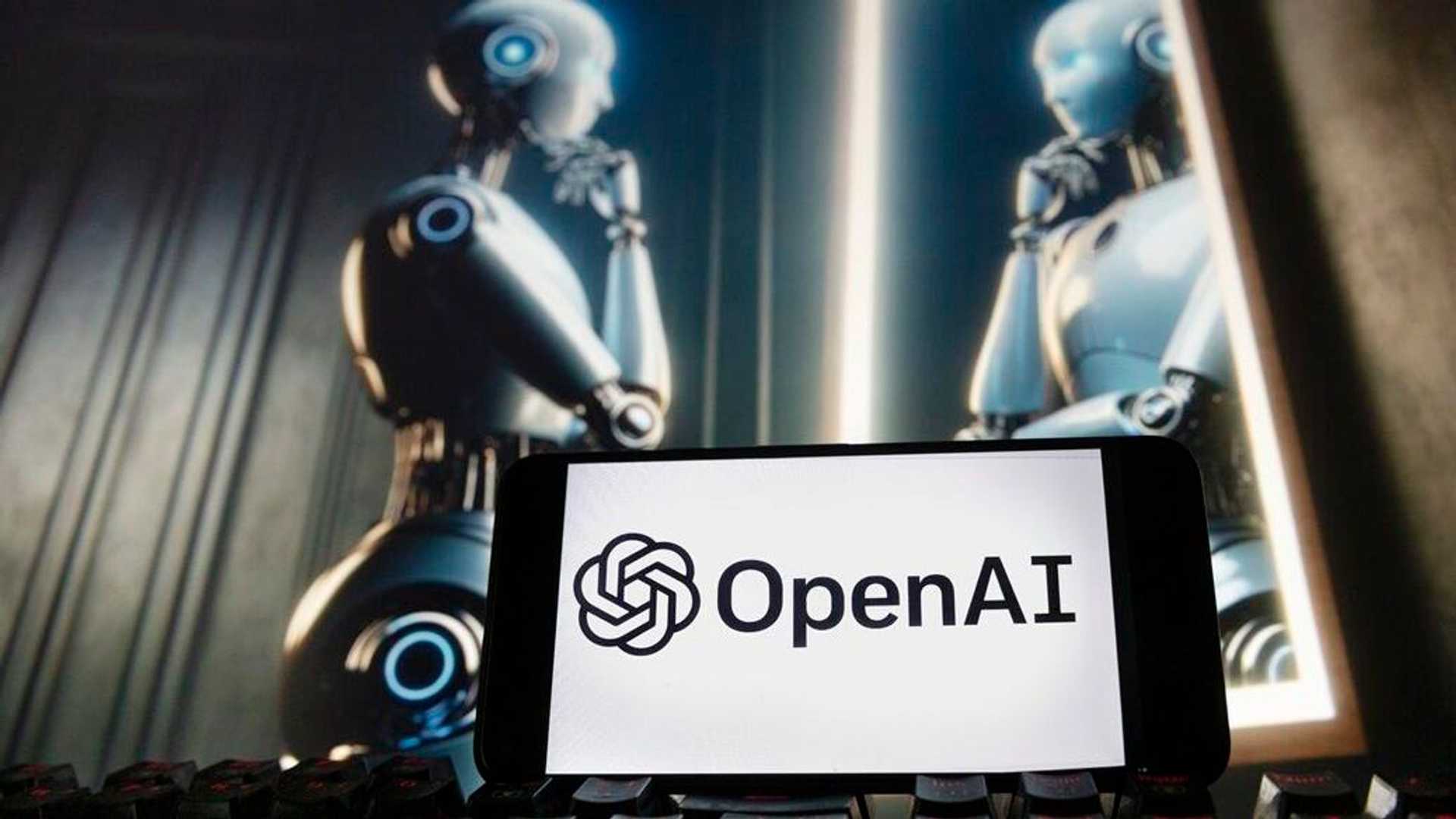 โลโก้ OpenAI บนหน้าจอมือถือ ตัดกับพื้นหลังหุ่นยนต์ AI สะท้อนคำถามเรื่องความปลอดภัยของบริษัท